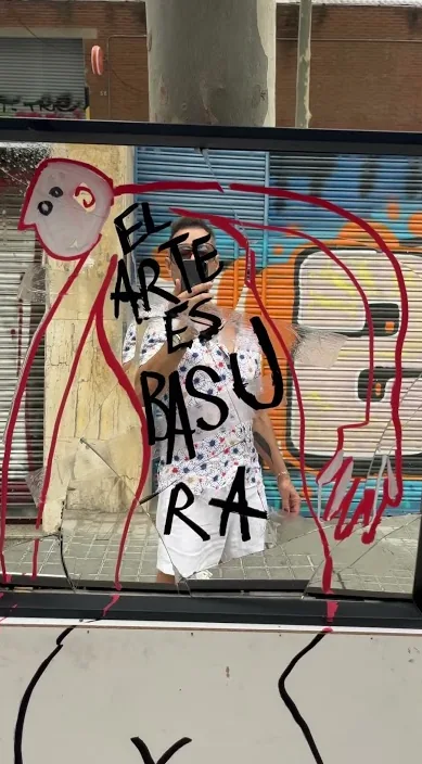 Butiksrullegitter med figurer og ordene El arte es basura, malet af Art Is Trash i Barcelona
